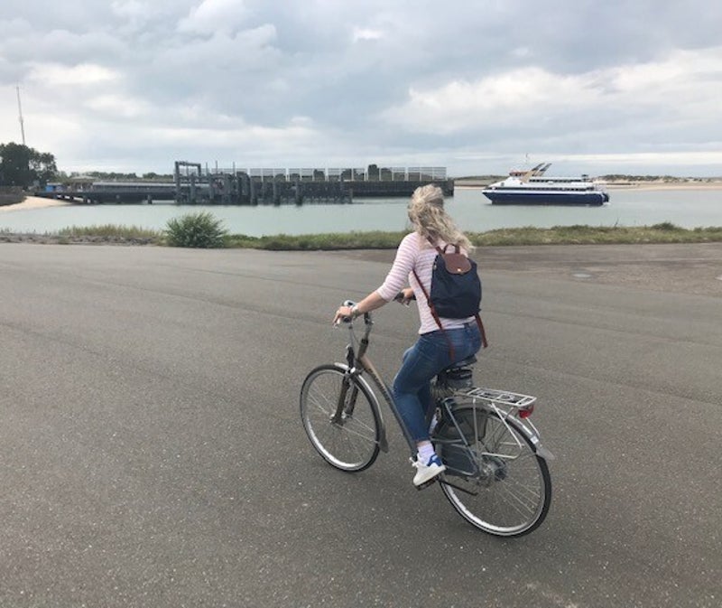 Een vrouw op de fiets - symbool voor bewegen voor vitaliteit kleine stappen met grote betekenis