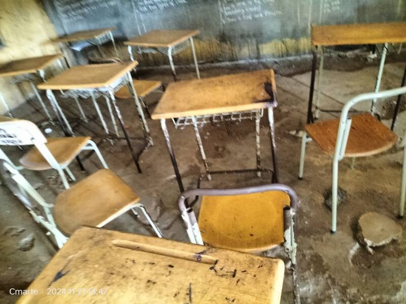 classroom with chairs and desks and badly damaged floor