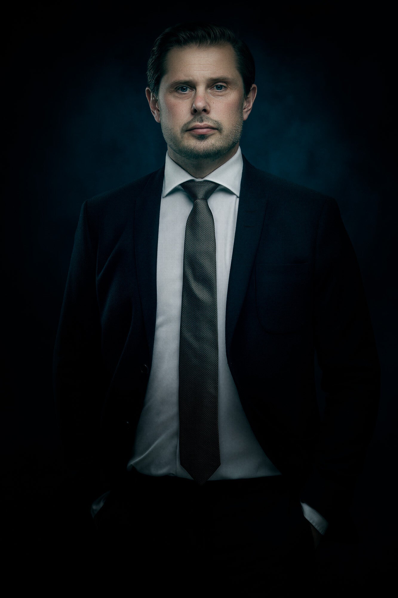 High-end zakelijk portret van een ondernemer in pak met donkere, filmische belichting die autoriteit en leiderschap uitstraalt zakelijke fotografie exclusieve zakelijke fotograaf Amersfoort en omstreken