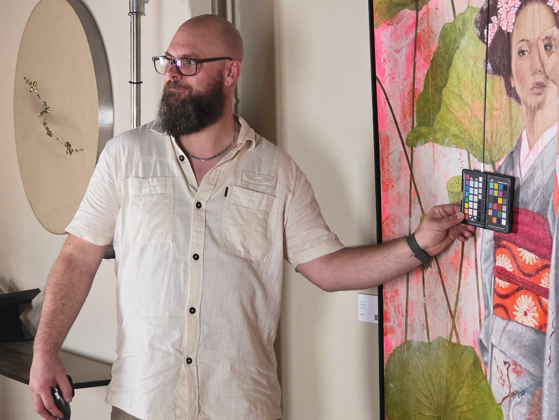 Reproductiefotograaf Mark Nederhoed voert een exacte kleurmeting uit met referentiekaart in het atelier van de kunstenaar