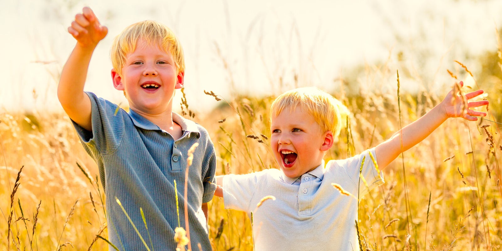 Portretfotografie met kinderen twee broerjes hebben lol tijdens de fotoshoot in het gouden uur fotoshoot op locatie
