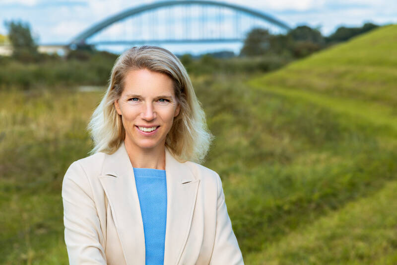 een zakelijke foto van een vrouw buiten met een brug op de achtergrond. zakelijke foto's buiten op locatie ook in Nijmegen en omgeving