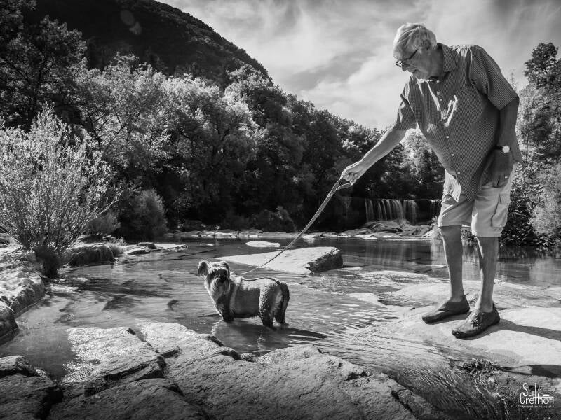 Man laat hond uit aan de de Cascade de La Vis - Frankrijk