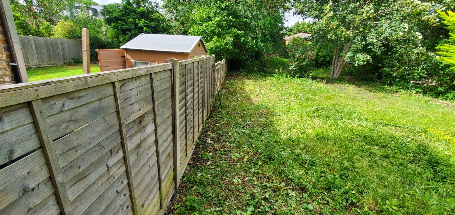 A neat and tidy garden clearance with freshly cleared borders and trimmed grass.