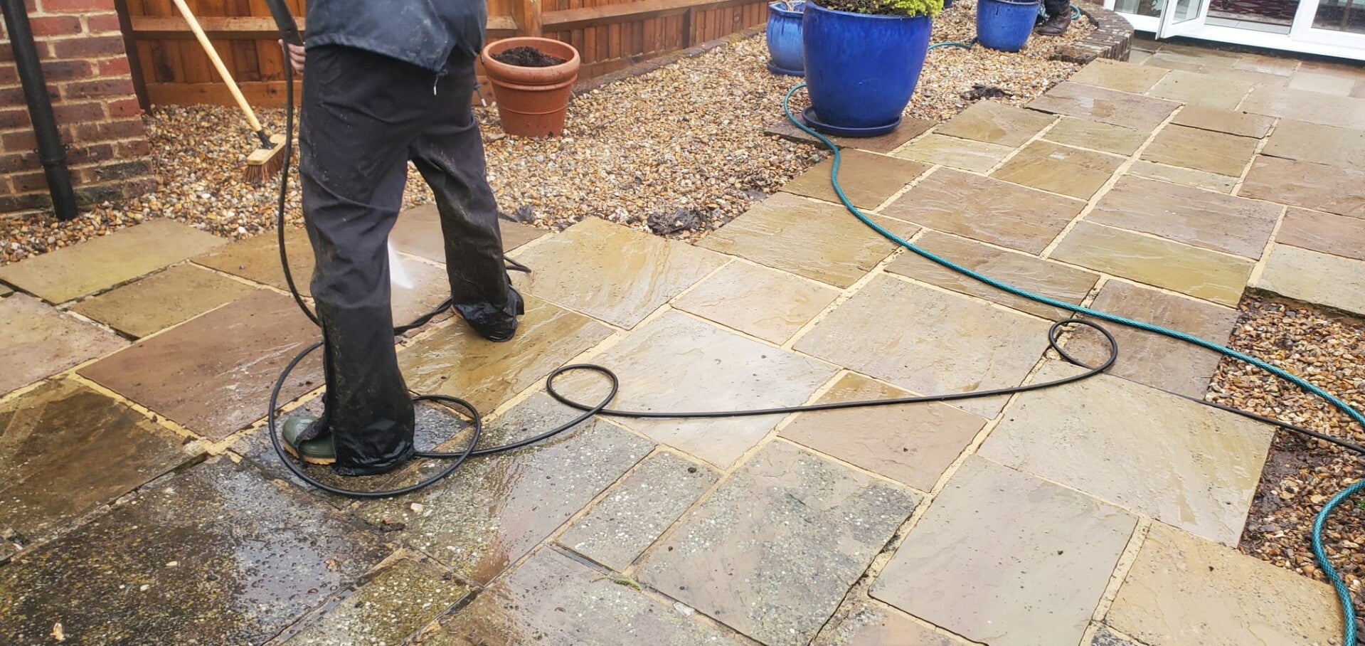A professional pressure washing service cleaning a residential pathway.