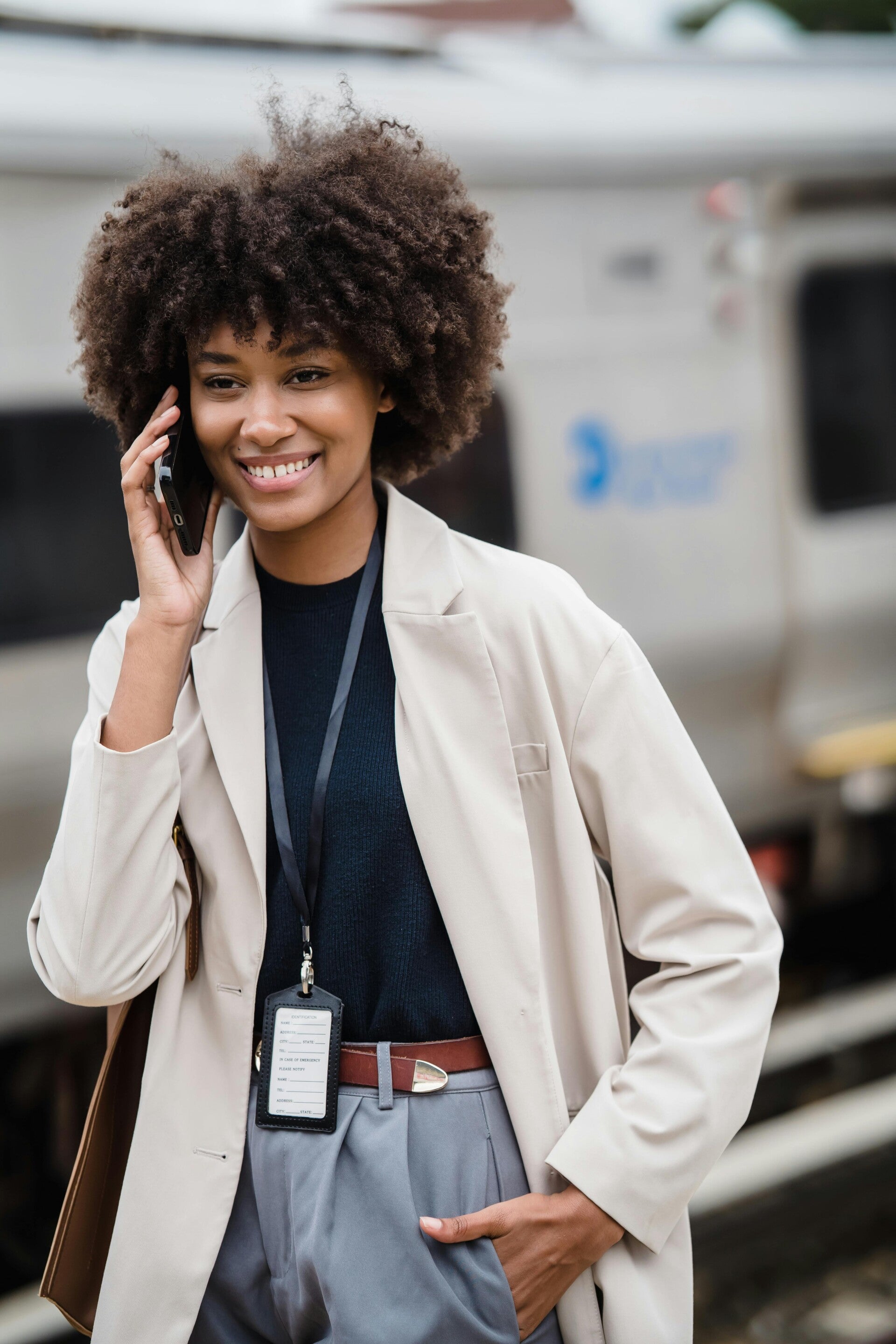 Smiling young woman with curly hair talking on a cell phone