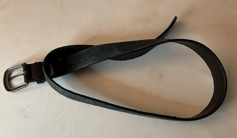 Ancienne ceinture en cuir noir utilisée pour récupérer une bande de cuir pour strop