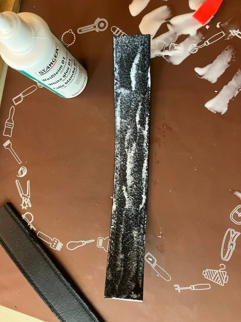 Collage de la bande de cuir sur le support en bois avec de la colle blanche
