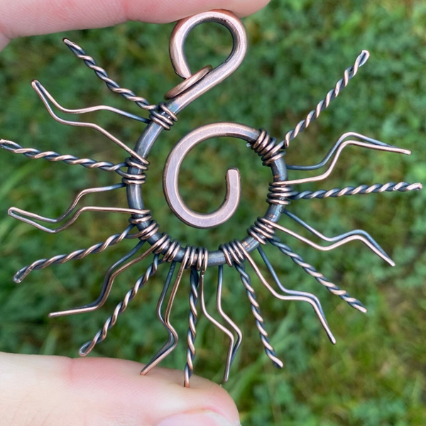 Sun spiral copper pendant.