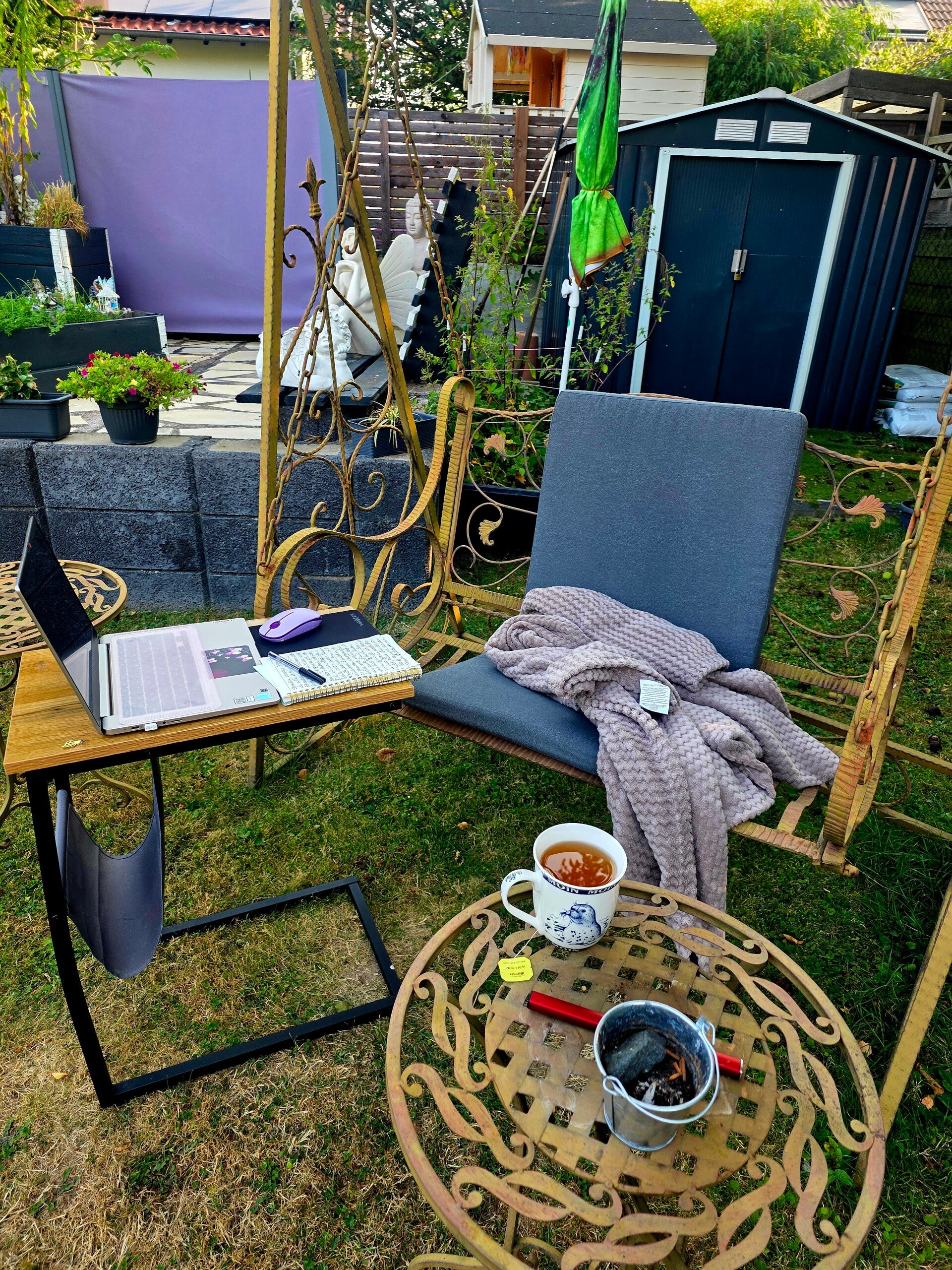Mein Schreibplatz auf der Schaukel im Garten mit Notizbuch, Laptop und einer Tasse Tee. Hier entstanden meine persönlichen Gedanken zu Engelsherz
