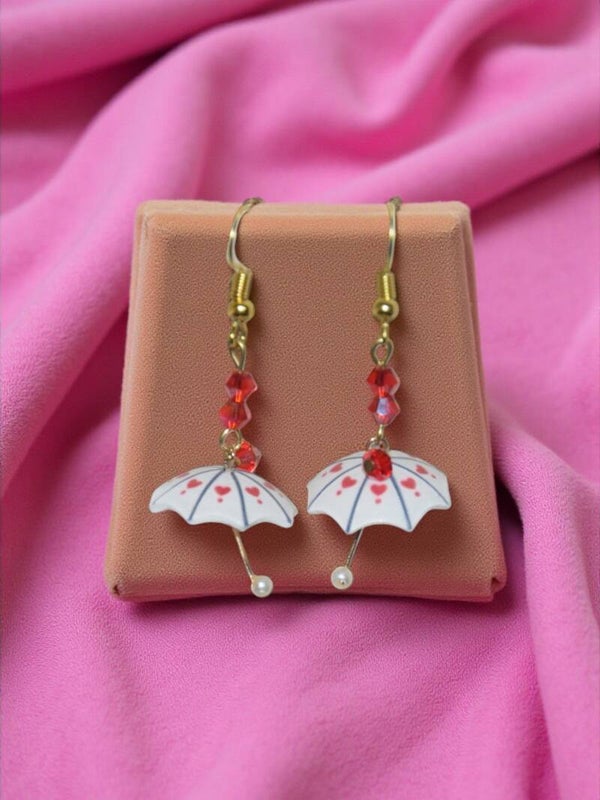 Boucles d'oreilles "Parapluies" composé de perles en cristal et d'un parapluie en acrylique. Acier inoxydable.