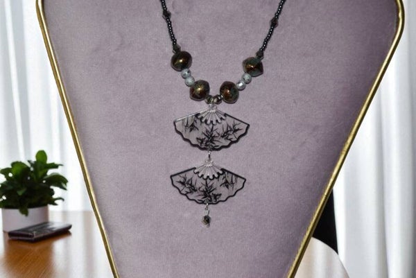 Collier "Eventails" 45 cm + extension composé de perles en cristal, verre, rocaille et de pendentifs éventails en résine. Acier inoxydable