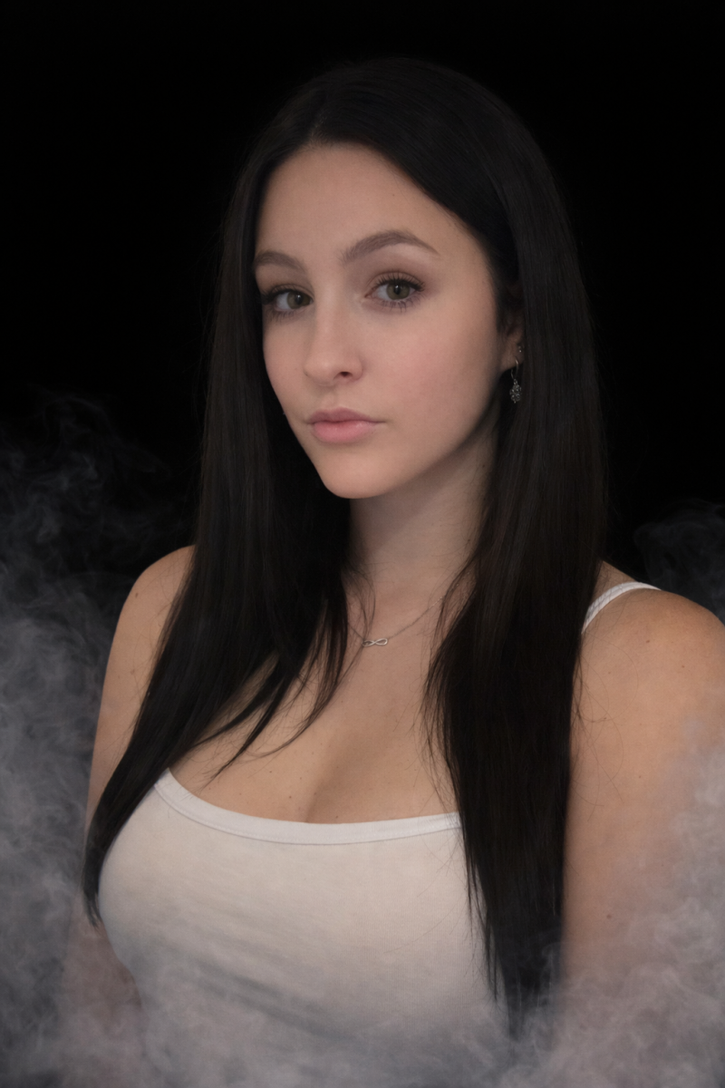 Lilsnowwhite aus der Schweiz – CamDiamonds Exklusivmodel mit langen schwarzen Haaren im Portrait vor schwarzem Hintergrund mit Rauch