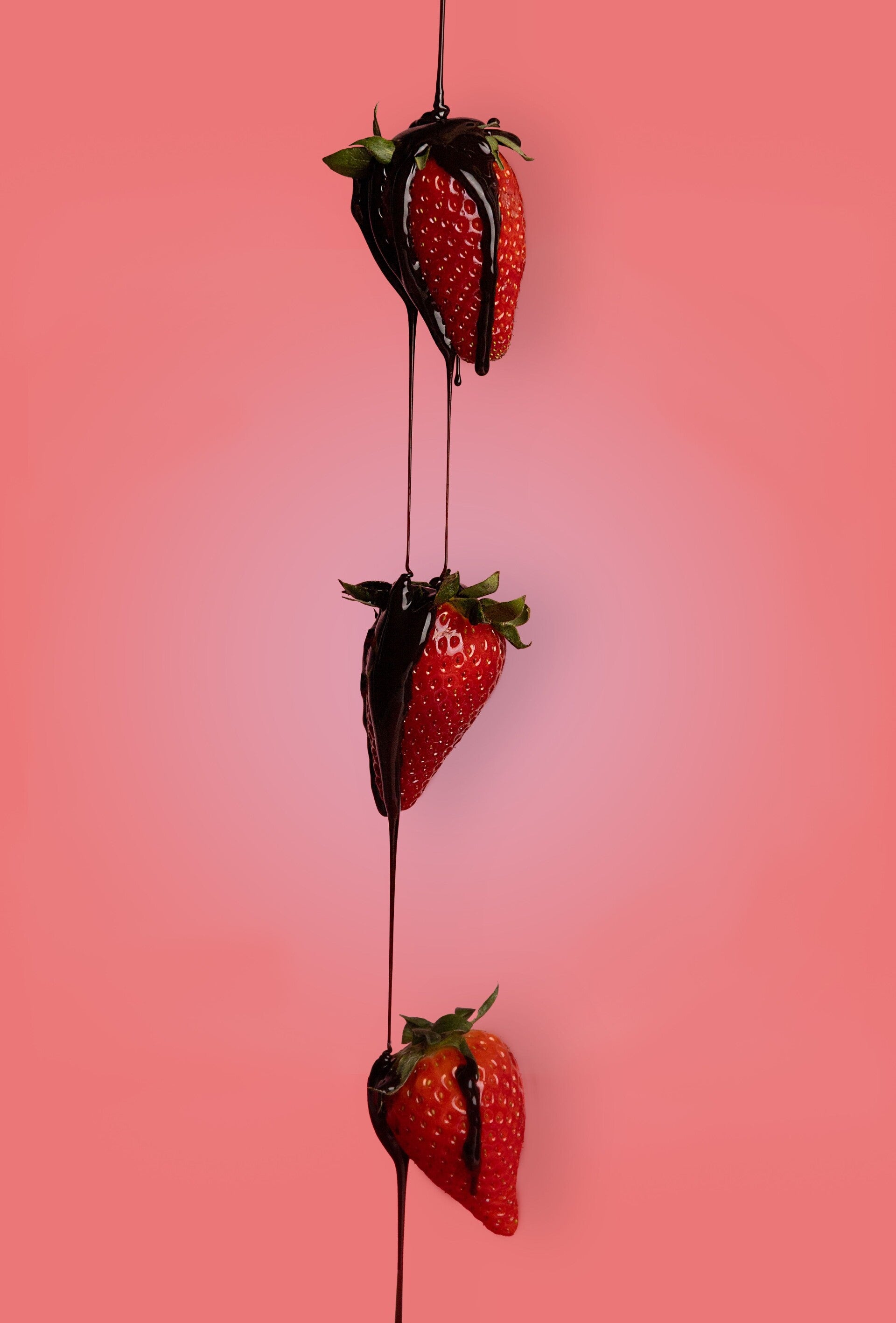Aardbeien met pure chocolade op een rode achtergrond.
