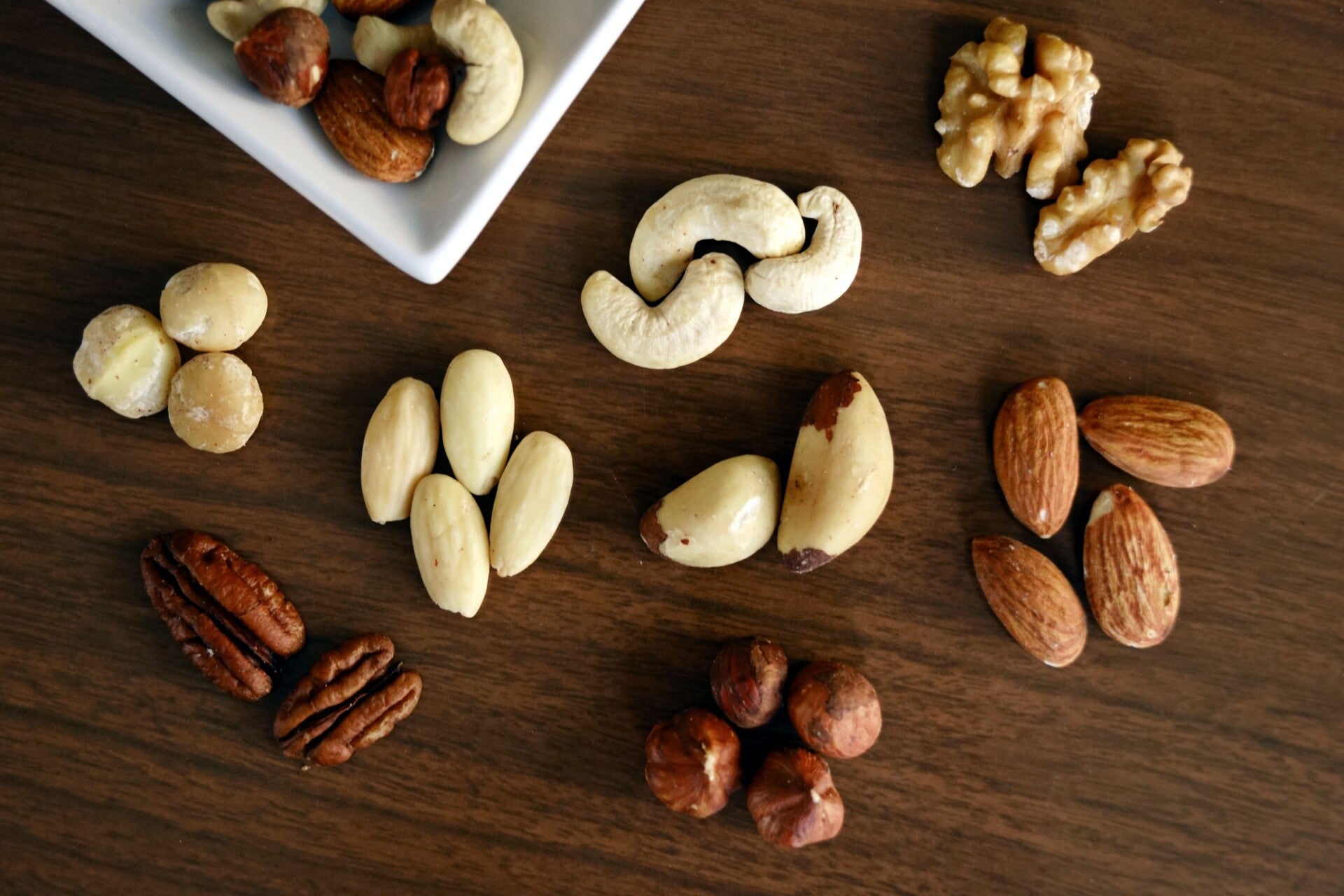 Amandelnoten, waltnoten, hazelnoten en cashewnoten op donker hout.