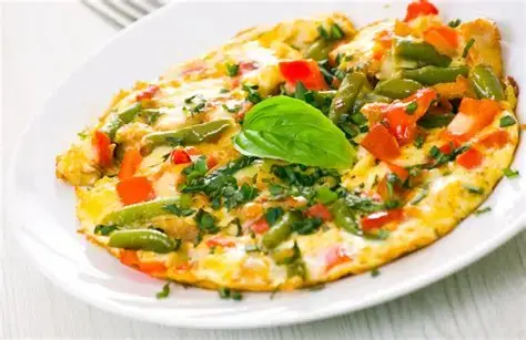 Omelet met groenten op een wit bord.