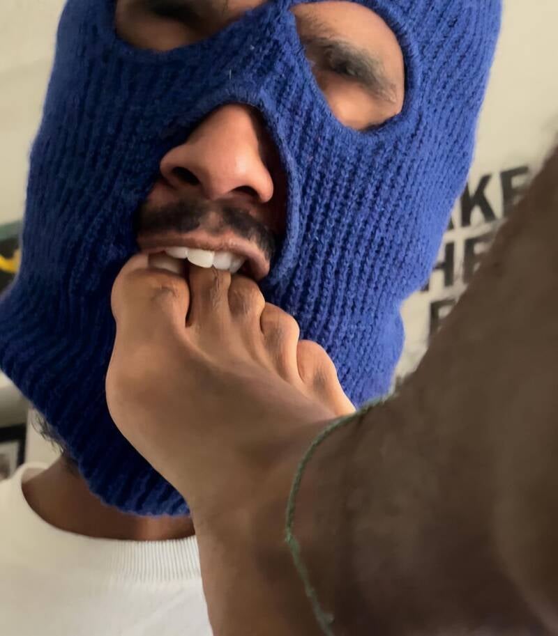 mGuy in blue ski mask put toes of another guy in his mouth. Showing foot worship.