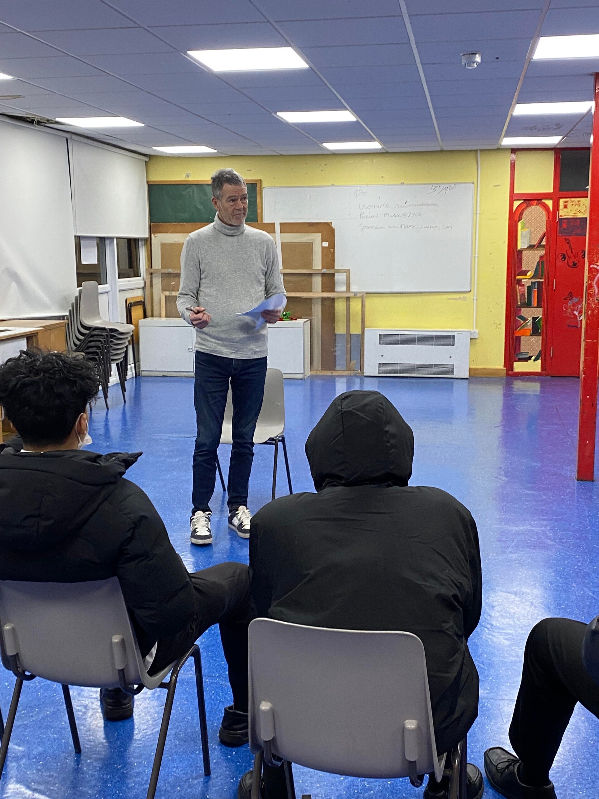 Johnathon Martin professionally mentoring a group of young men aged 15-18 in a London school setting. The image captures an interactive resilience workshop focused on personal development and life skills.