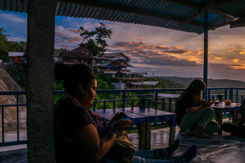 A sunset picture of two women siting in a small restaurant that is overlooking Yogyakarta from Bukit Bintang