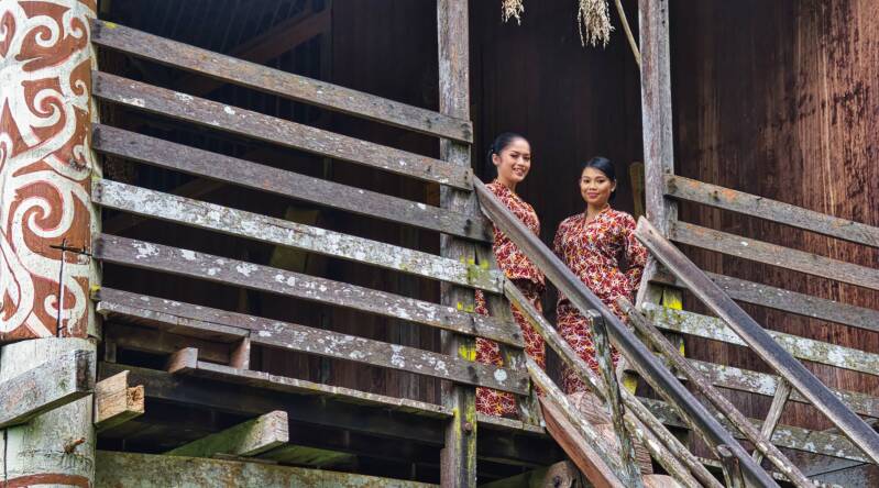 Two girls of the welcome committee of Kampung Budaya in a replica of an Orang Ulu Longhouse in Sarawak Cultural Village, Sarawak Borneo, Malaysia