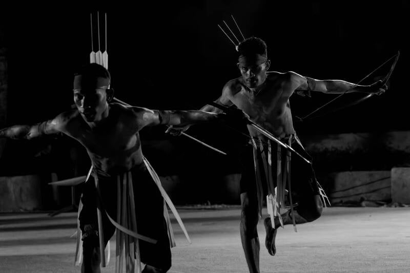 A black and white photo of a Moluccan war dance performance called Cakalele during the 75th anniversary of Yudas Thadeus Langgur, Kei Kecil, Indonesia