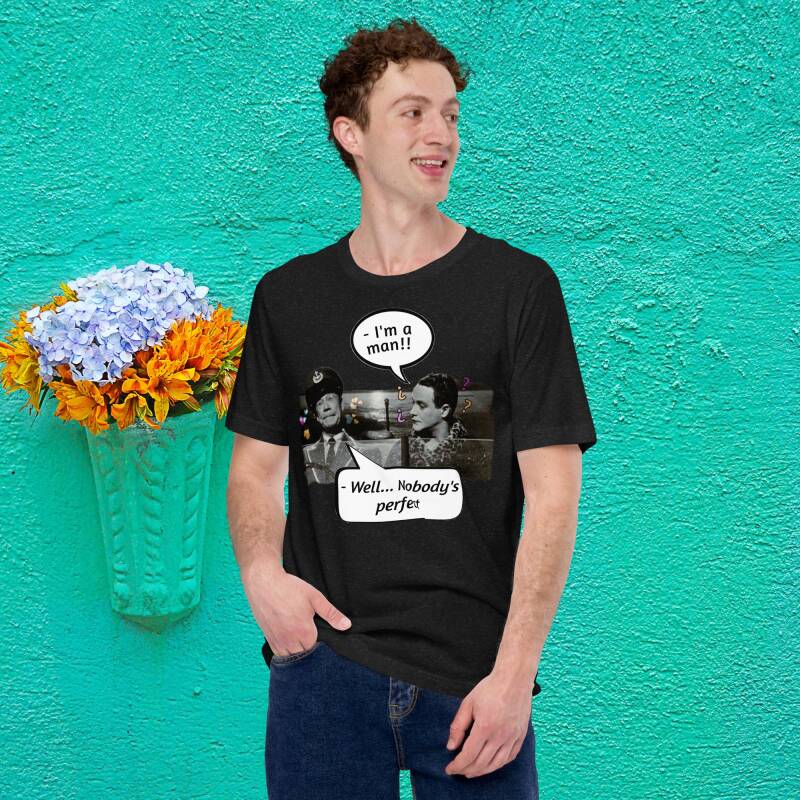 Modelo hombre con camiseta negra "Con faldas y a lo loco", resaltando la famosa frase "-Soy un hombre!... -Bien, nadie es perfecto".