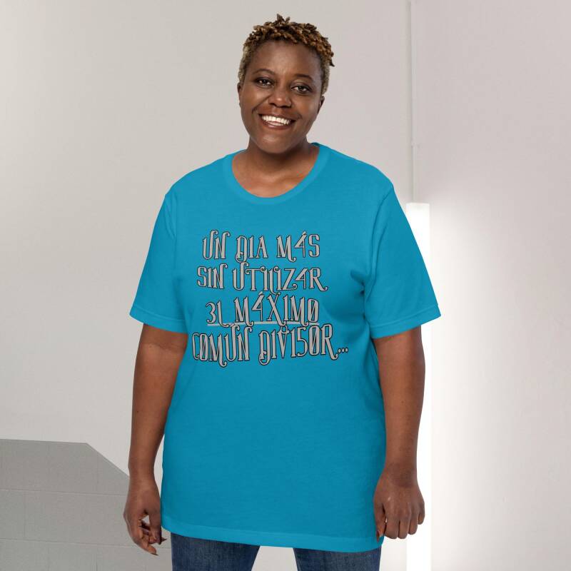 Mujer sonriendo con camiseta "Un dia más sin utilizar el máximo común divisor" (texto numérico), en un ambiente relajado.