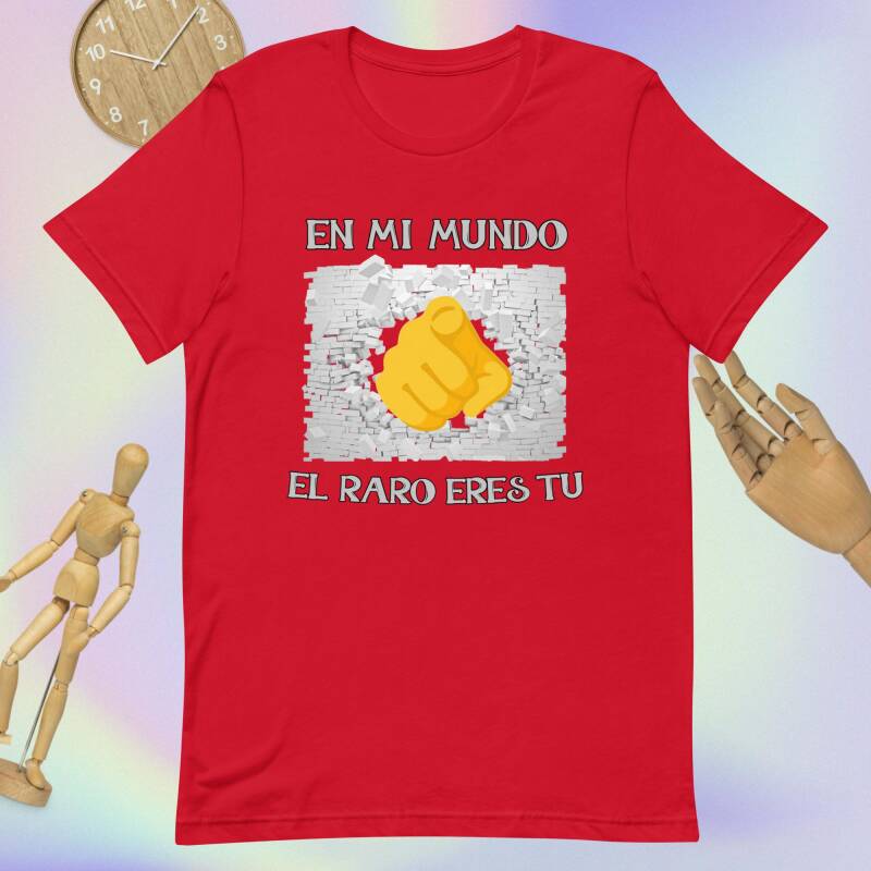 Camiseta con dedo señalando al frente atravesando pared de ladrillo blanca con frase "En mi mundo el raro eres tú" Camisetas estampadas frikis
