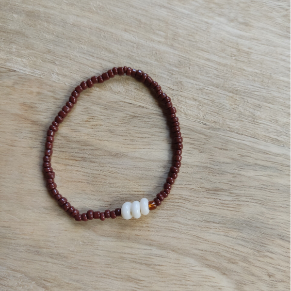 Handgemaakte armbandje met 3 crèmekleurige kralen in combinatie met bruine glaskraaltjes.