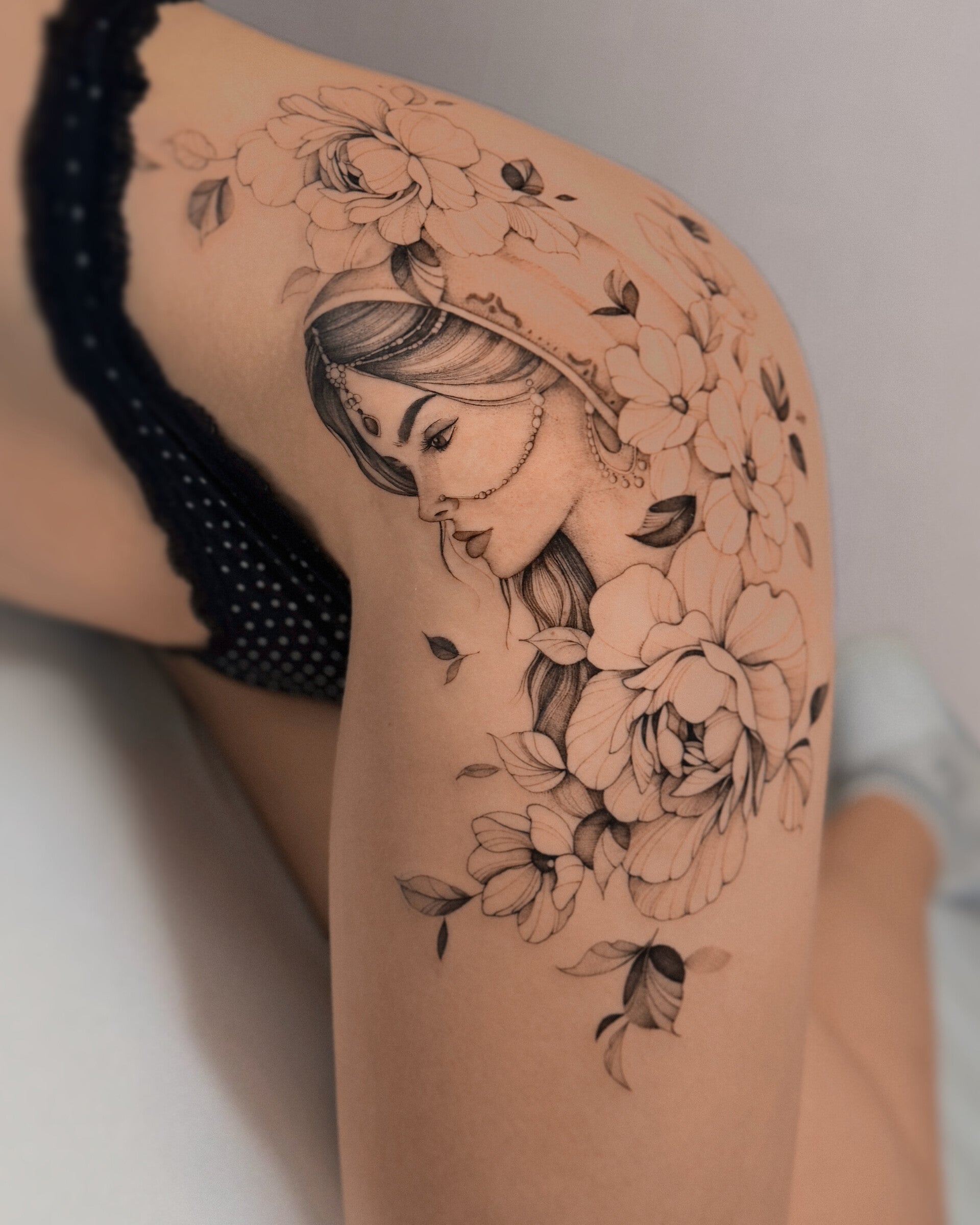 delikatny tatuaż fineline portret i kwiaty na udzie Olszty