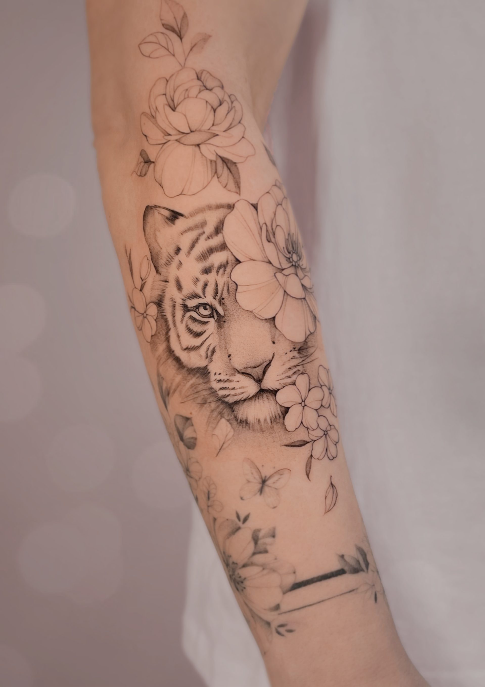 kobiecy tatauaż tygrysa w delikantych kwiatach na przedraminiue w Olsztynie 