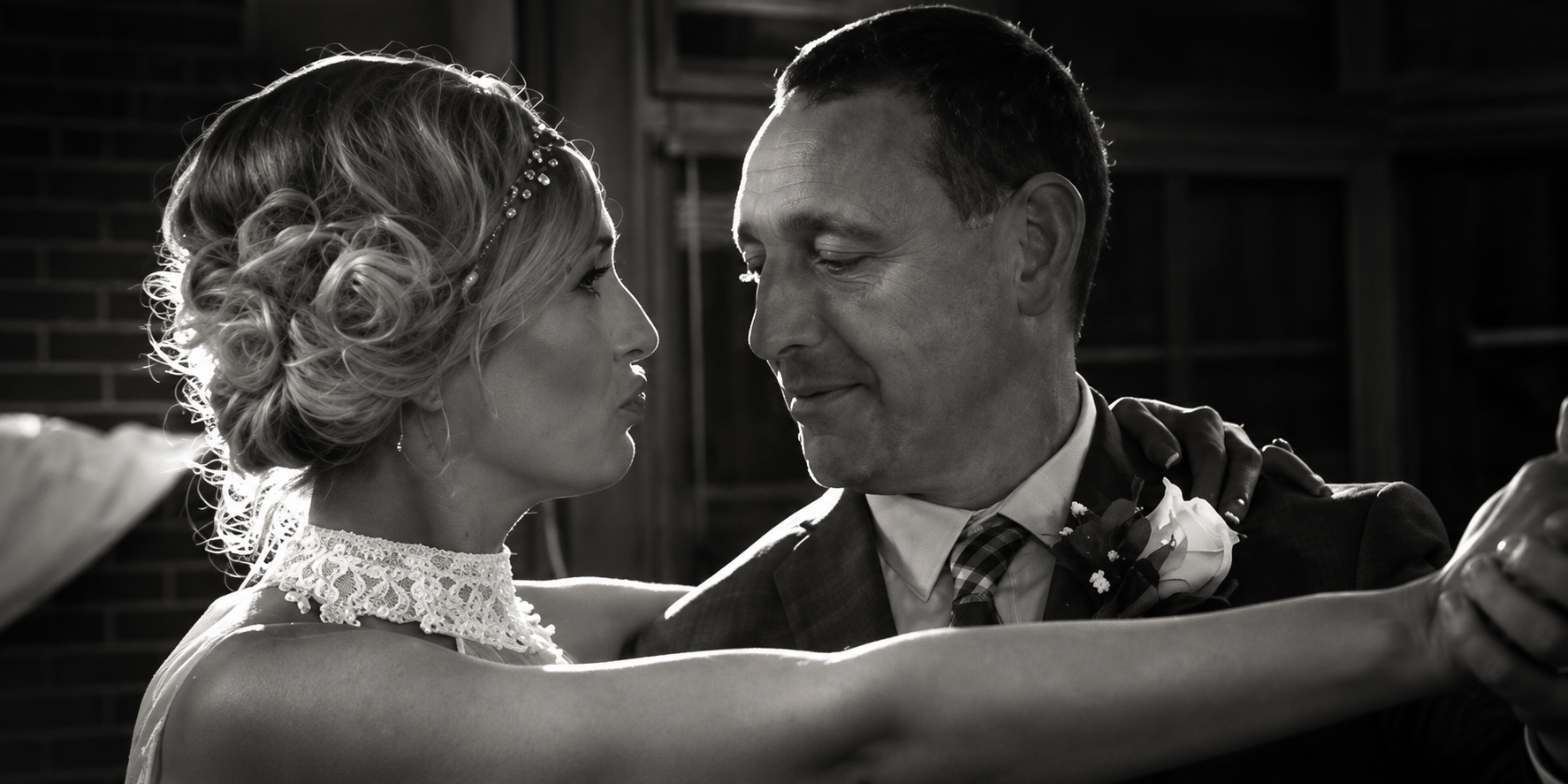 Black and white photograph of a couple facing each other closely.
