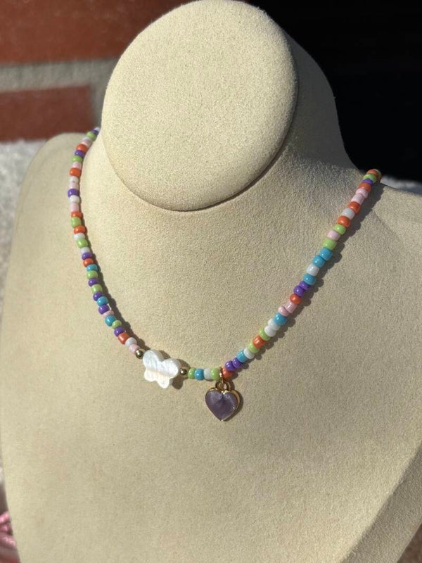 Kinderketting multicolor met vlinderkraal en hartjesbedel.
