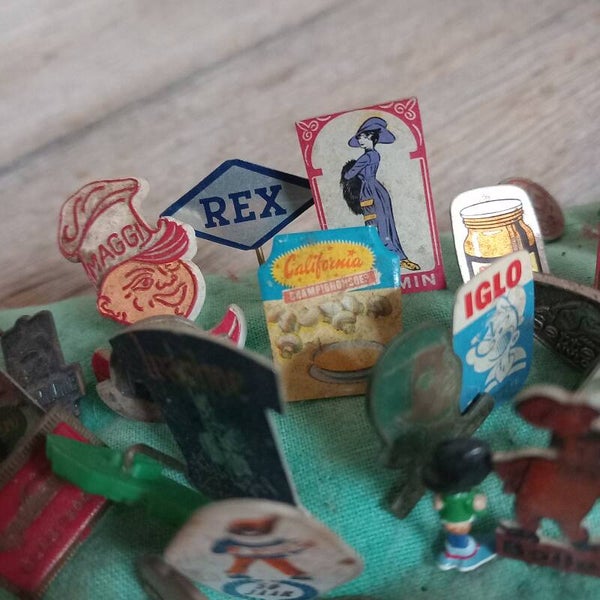 Speldenkussen met reclamespeldjes.