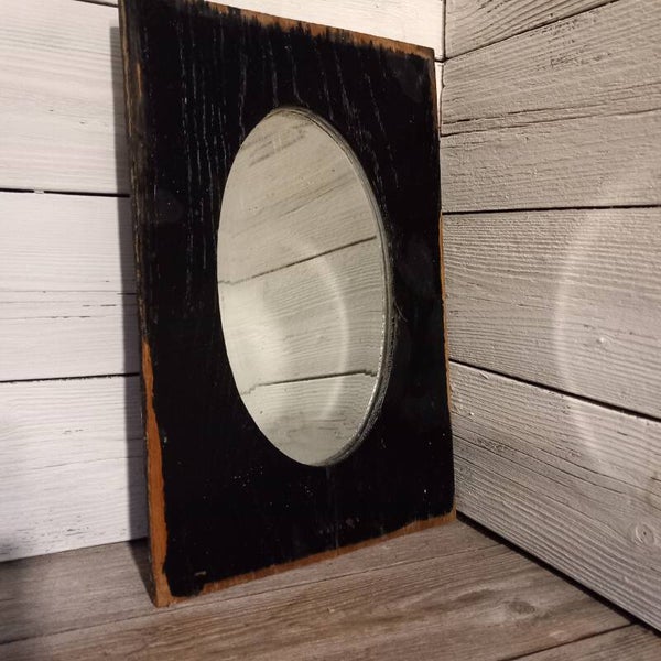 Eenvoudige antieke spiegel met facetrand in houten framewerk.