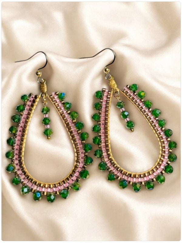 Statement oorbellen met glinsterende groene en lila glaskralen