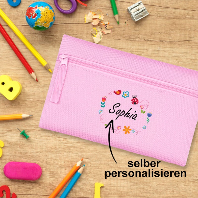 ein Set DIY Schulaufklebern zum ausschneiden und beschriften - mit Einhornmotiv in Lila und Rosa, ein Heftaufkleber klebt auf einem Schulheft, weitere blanko Namensaufkleber sind auf Lineal und Trinkflasche geklebt.