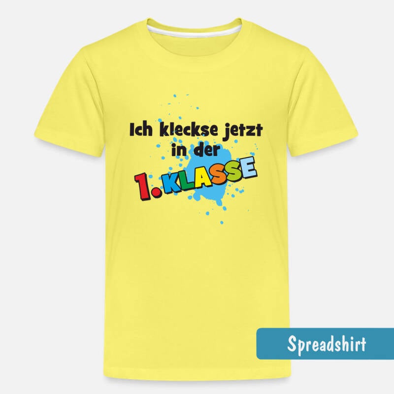 gelbes Einschulungs-T-Shirt. Motiv: blauer Farbklecks - darauf der Text : Ich kleckse jetzt in der 1. Klasse. Der Schriftzug: 1. Klasse ist in bunten Buchstaben geschrieben, der restliche Text in schwarz