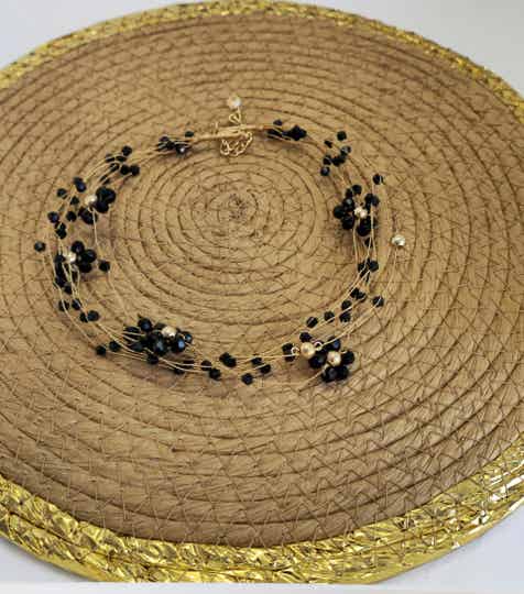 Gargantilla semi rígida con piedras negras formando flores