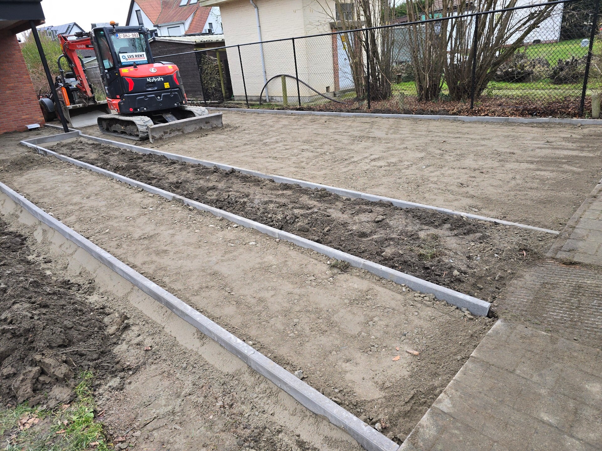 Uitgezet grondwerk met geplaatste boordstenen, klaar om de bestrating in te leggen.
