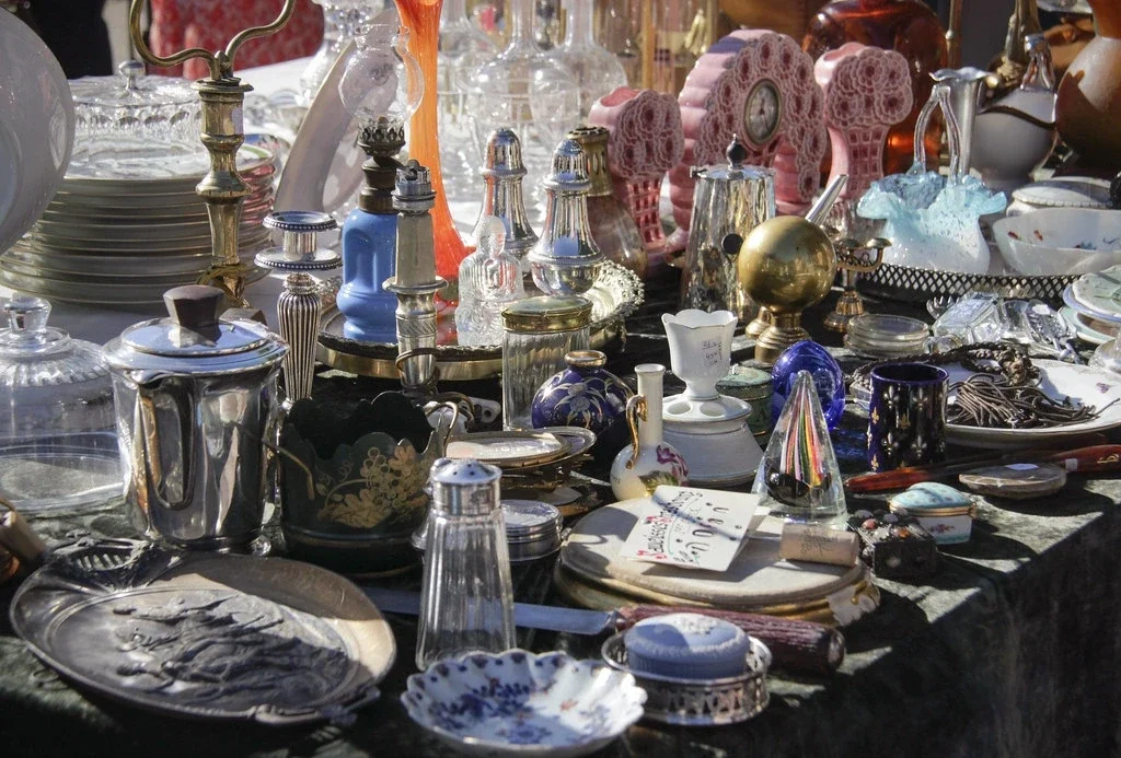 Une photo représentant divers objets de brocante, telles qu'un vase et un tableau