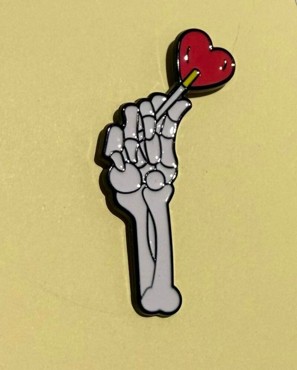 Skeleton hand and heart pin