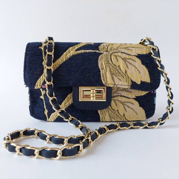 Leren damestasje - omtrokken met stof - messing schouderketting - blauw - motief bladeren/bloemen - goud kleur - roze kleur - draaiknopje - opvallend