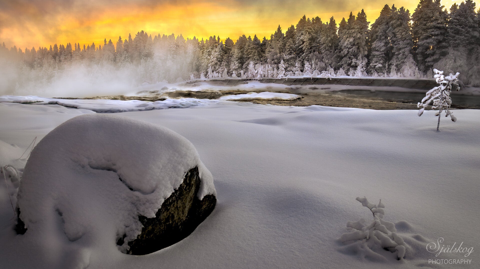 The golden light catching the mist is absolutely beautiful. The frozen cascades and snow-draped surroundings create a magical scene that feels almost otherworldly.
