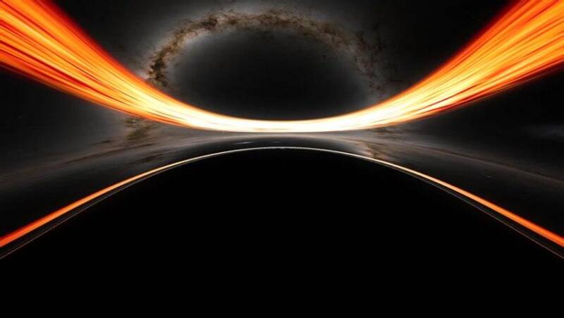 Illustration of a black hole surrounded by a glowing accretion disk and its event horizon.