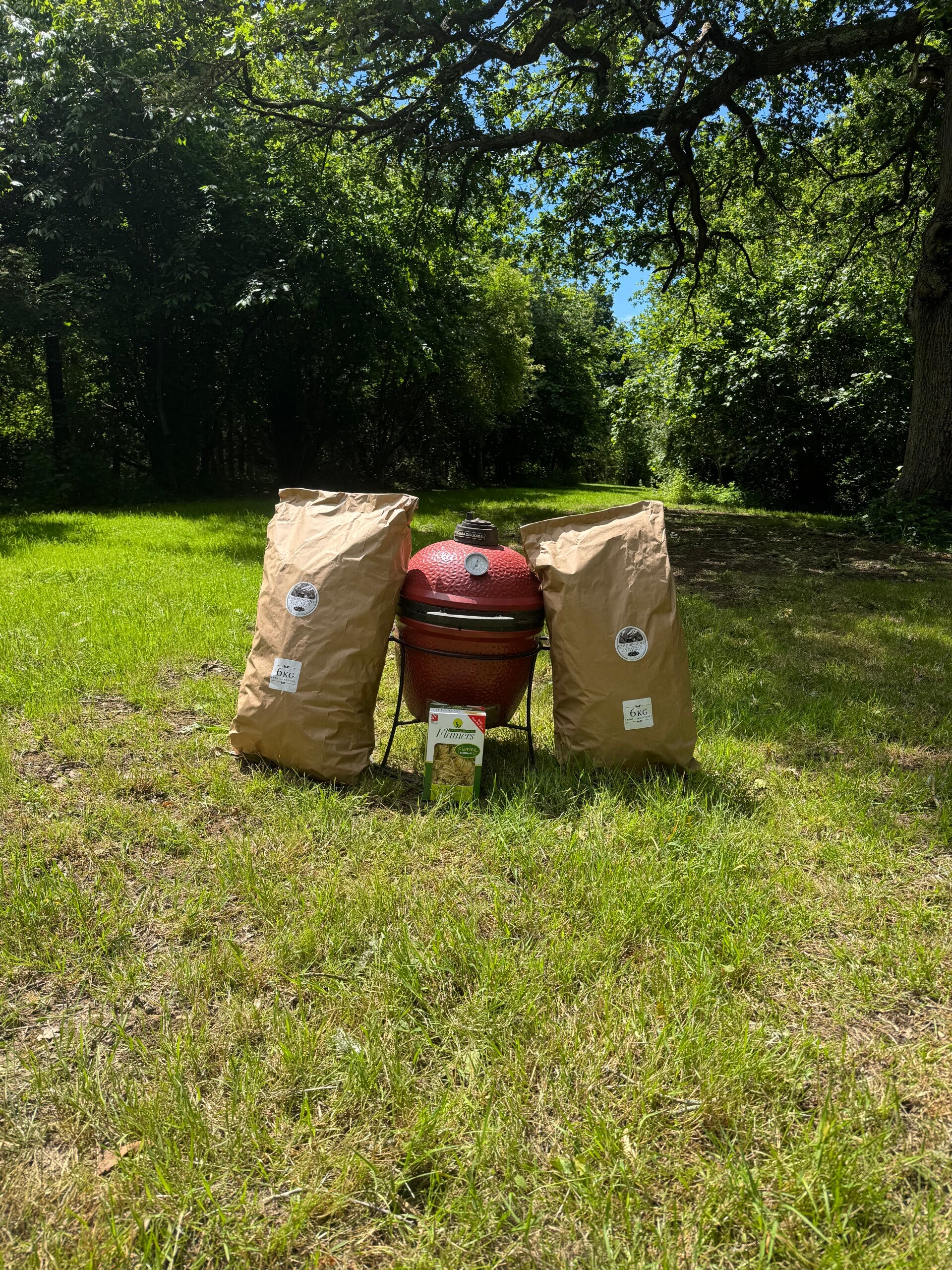 Bags of Chiddingfold lumpwood barbecue charcoal made from sustainably managed British woodland, stacked ready for sale.