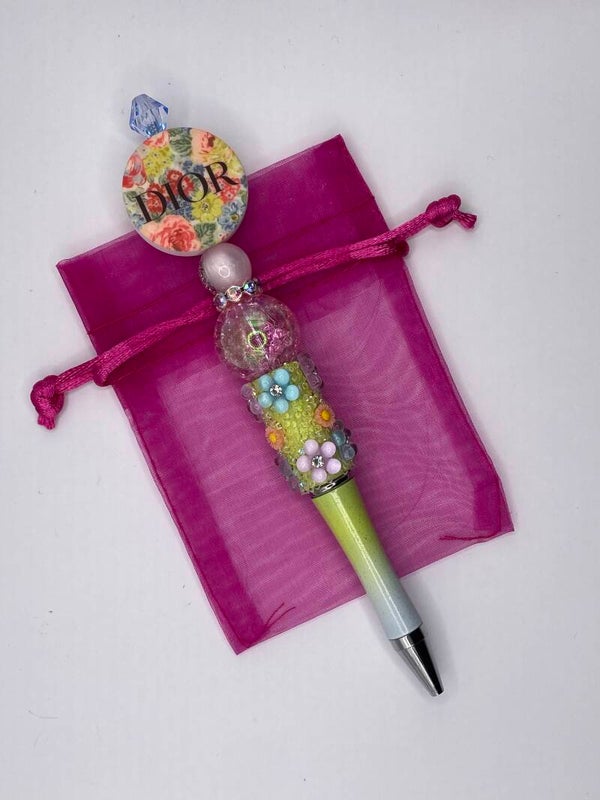 Merkpen Dior met bloemenkralen rond logo