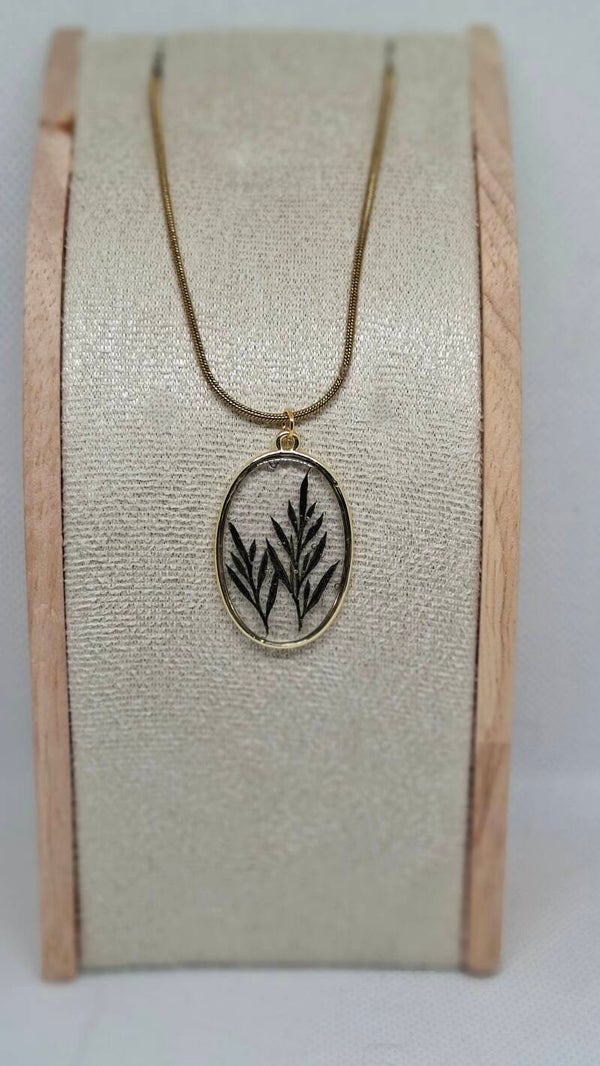 Ketting goudkleurig met ovale hanger gevuld met gedroogd blad