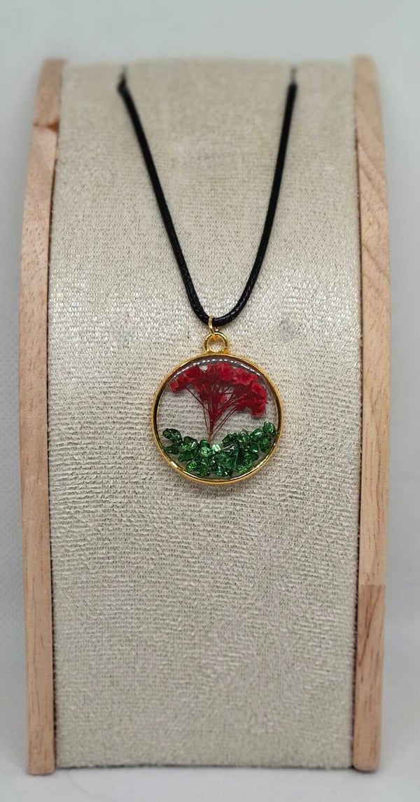 Goudkleurige ronde bedel met rode bloem en groene steentjes, ketting imitatieleer