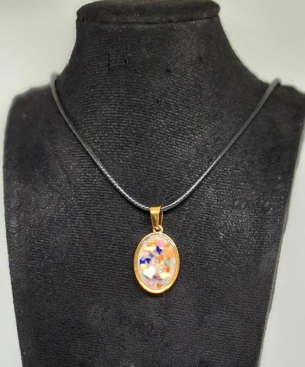 Ketting zwart waxkoord met goudkleurige bedel gevuld met epoxy en schelpensnippes